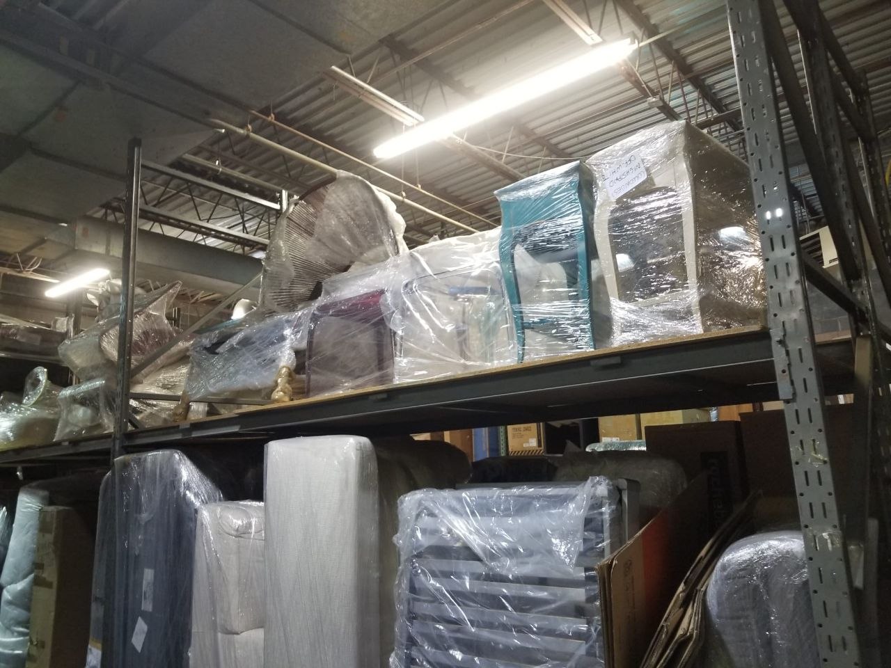 Wrapped furniture stored on warehouse shelving